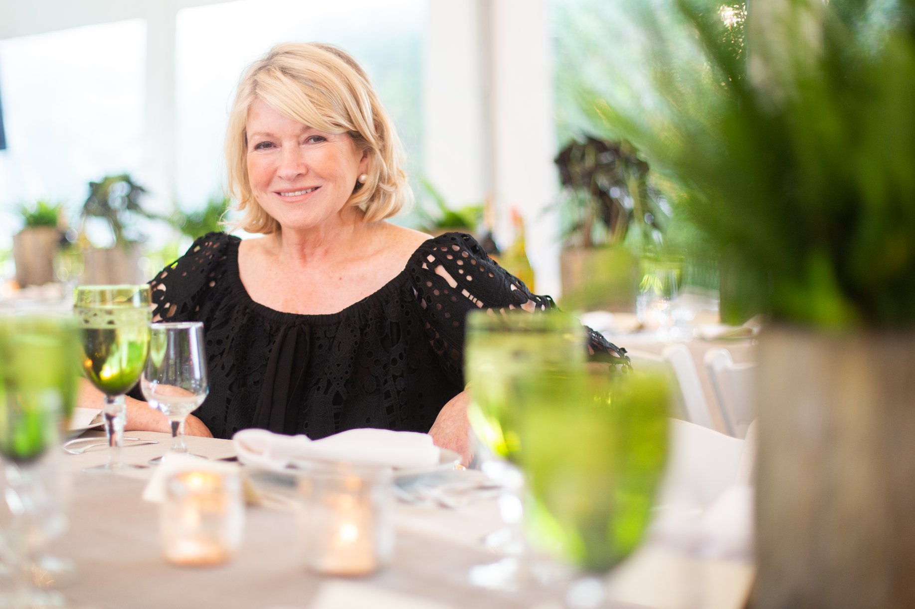 Martha Stewart seated and smiling at a Golden Circle event in the Hamptons